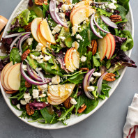 Winter salad with apple, red onion and roasted pecans with vinaigrette dressing